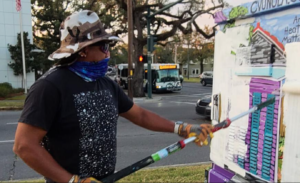 An unidentified vandal applies white paint over an artwork by Heather Mattingly.