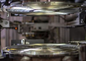 The inside of a record press has two stampers with microscopic grooves that make the vinyl plastic into a playable record.